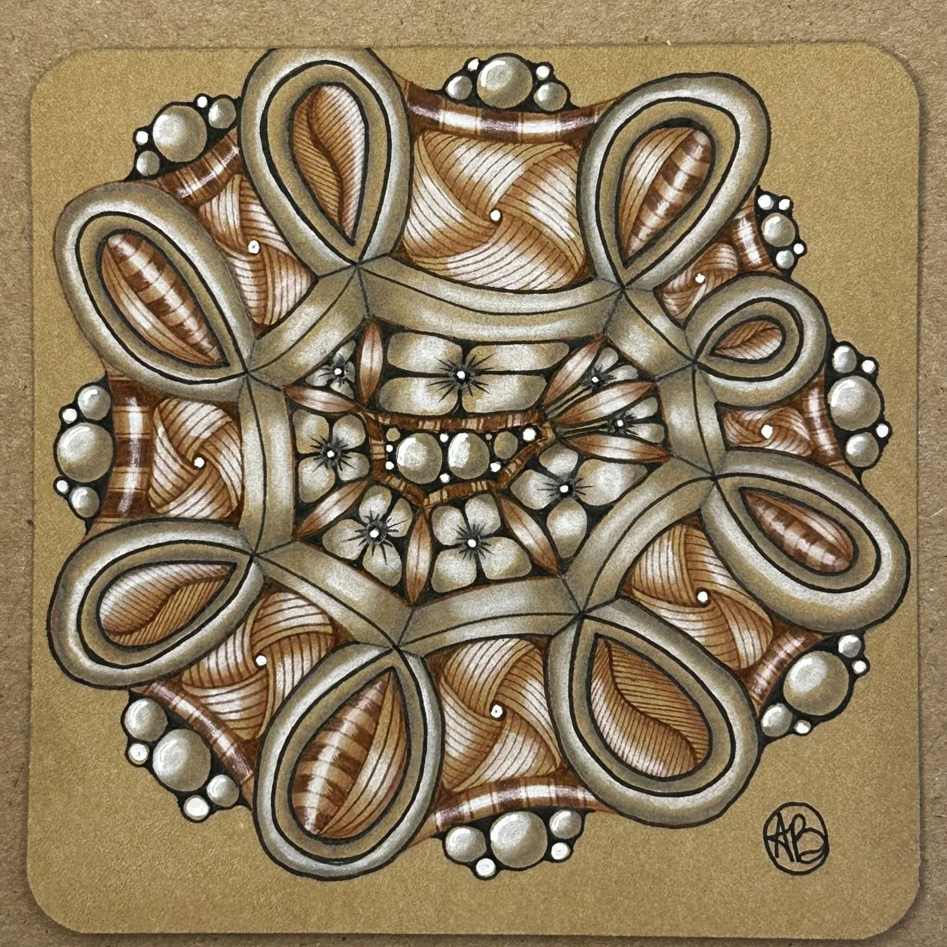A detailed, abstract mandala with layered, ribbon-like shapes, floral patterns, and bubble accents in shades of brown, cream, and black on a gold background.