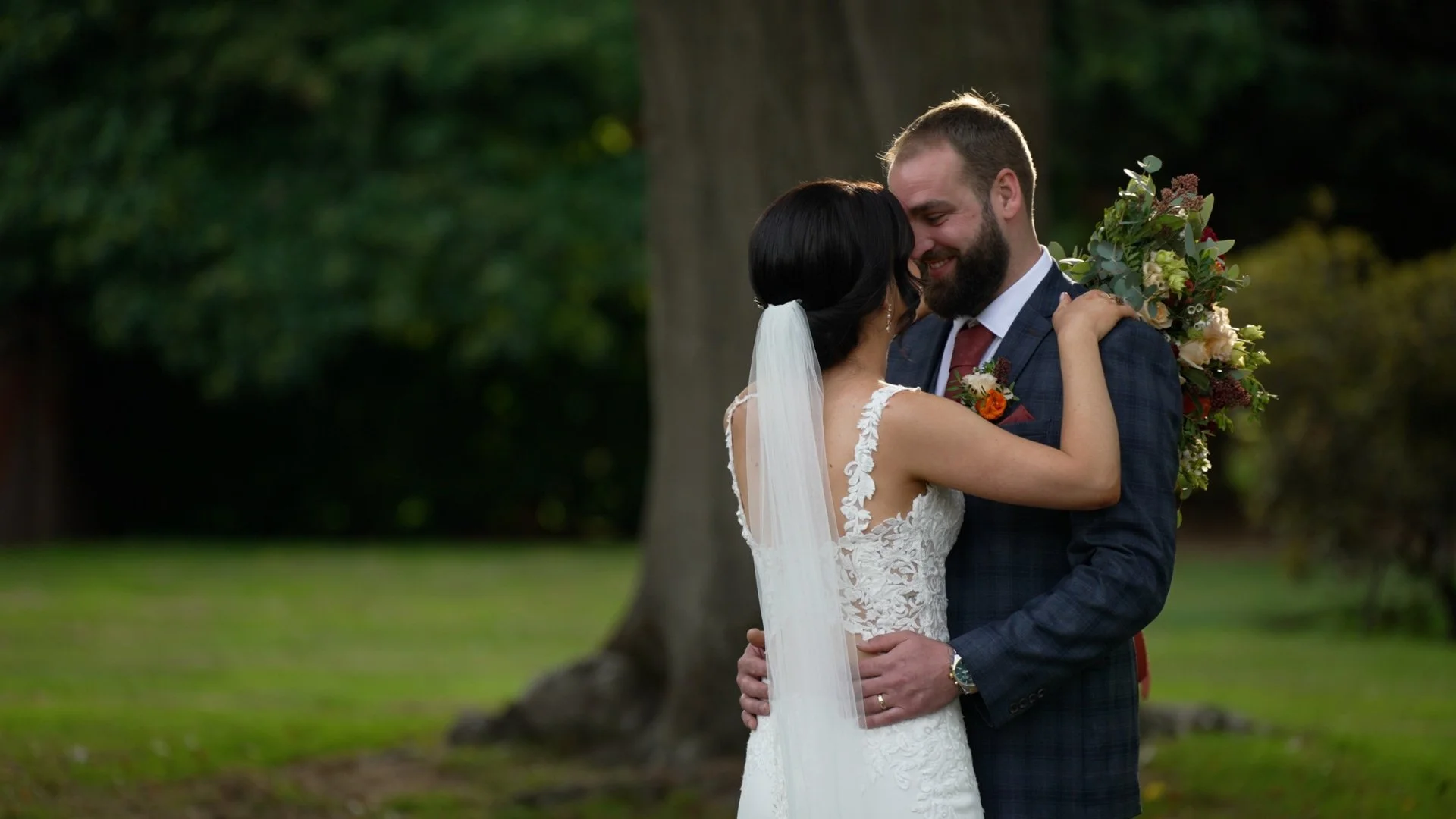Wedding day Orsett Hall Couples kiss with bouquet of wedding flowers natural videography