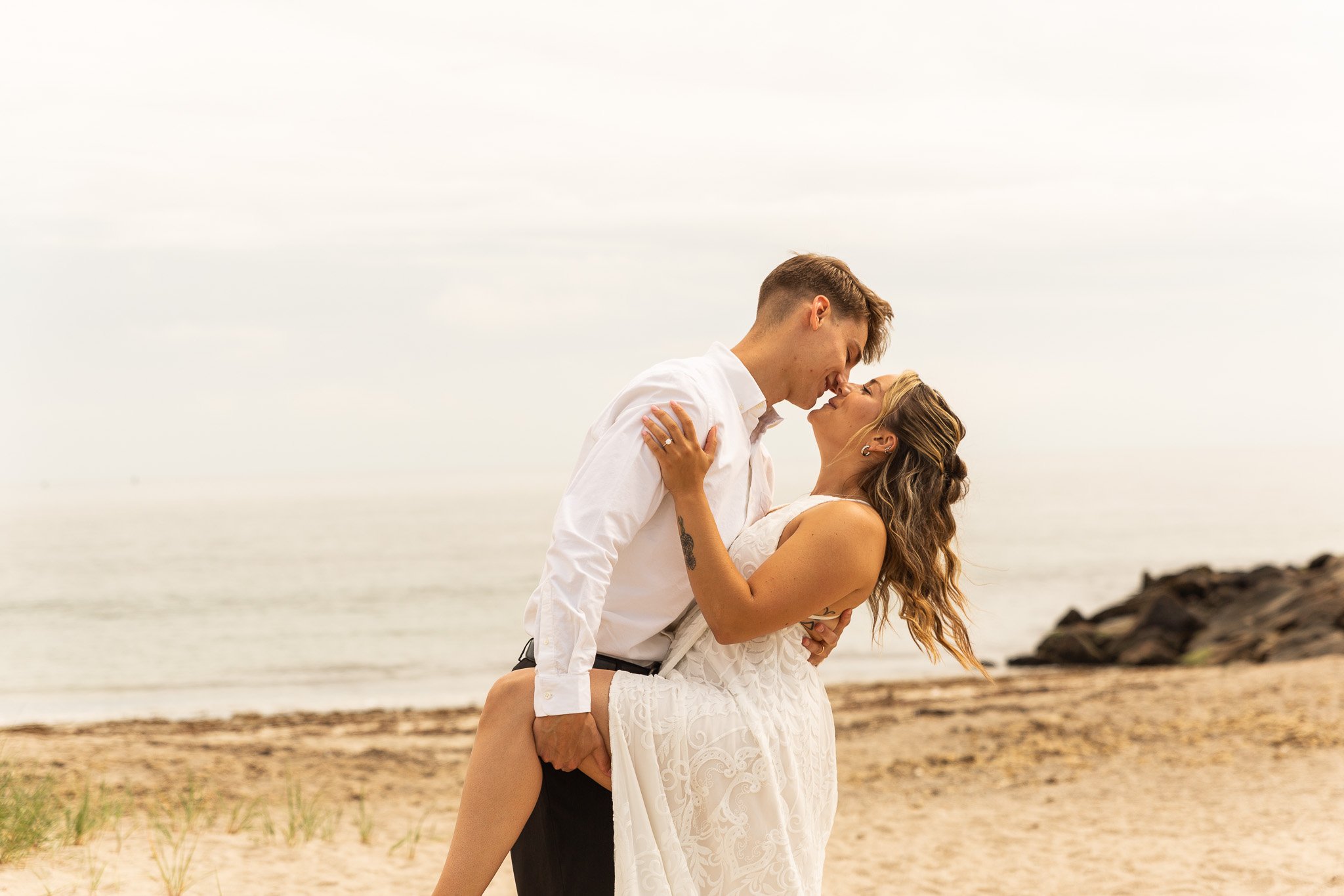 couple embracing while elopeing on beach in Napatree Point Rhode Island