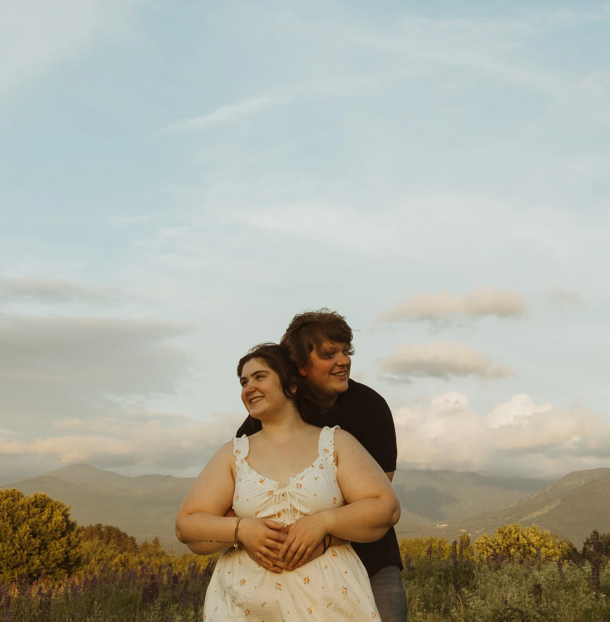 A couple hugging in a lupine field during an adventure elopement