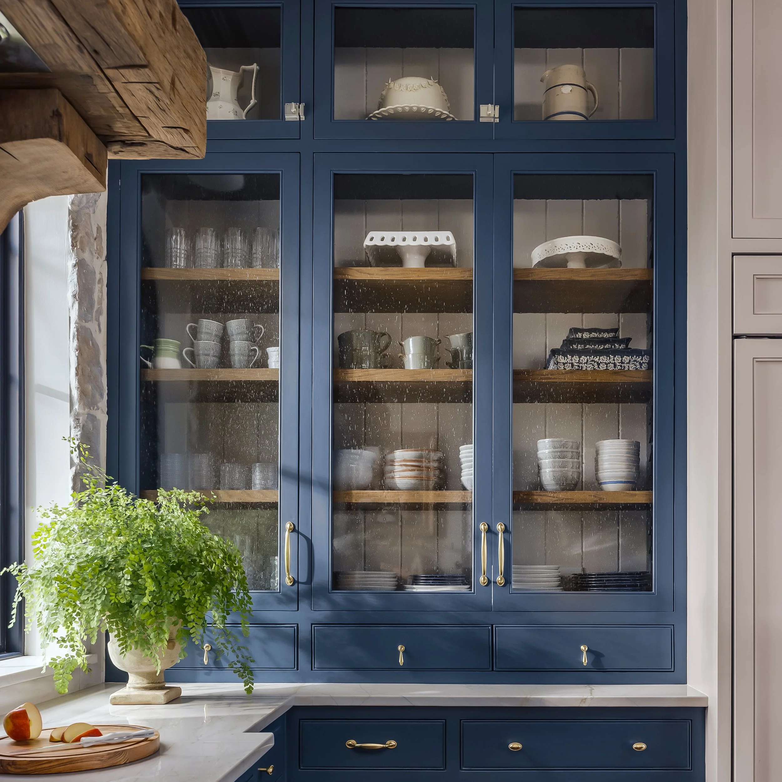Old-world charm, built from scratch. Even the shelf supports are custom &mdash; a hand-notched batten strip standing in for standard peg holes, so the joinery itself feels old world. Add reclaimed oak, seeded glass, and unlacquered brass, and you've 