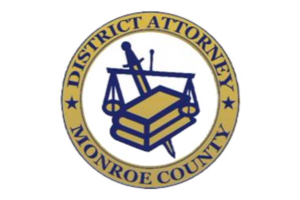 Official seal of Monroe County District Attorney's Office, featuring a sword, a gavel, and a stack of books in the center, surrounded by a circular border with the text 'DISTRICT ATTORNEY' and 'MONROE COUNTY'.
