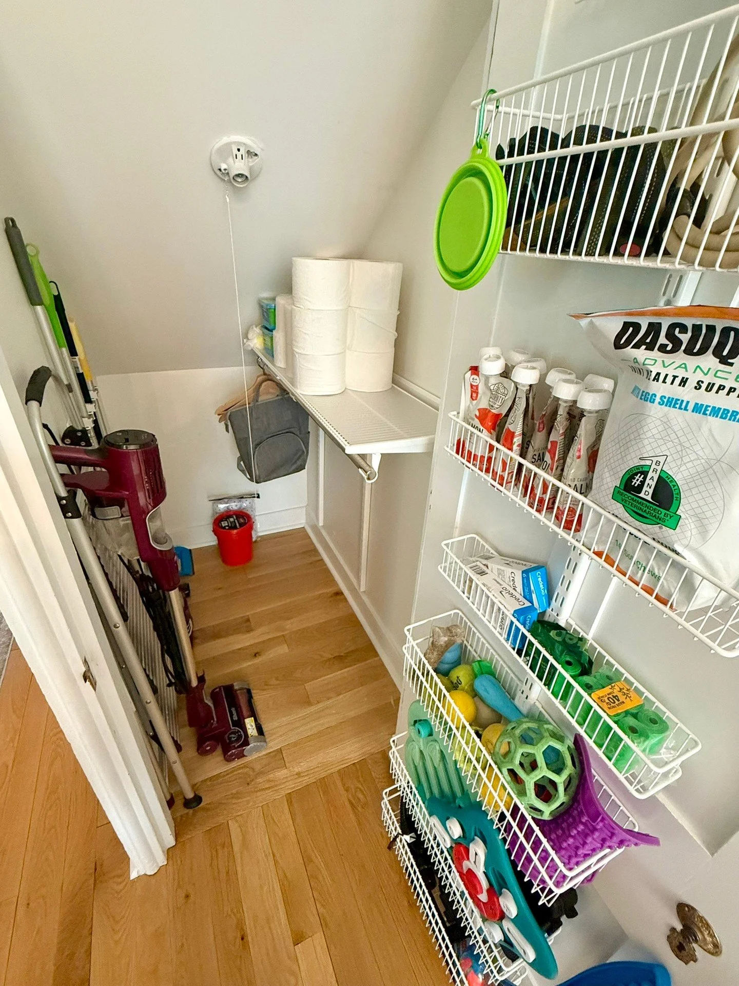 Can you believe this under the stairs space was once a toilet? 

The homeowners had it redone into a storage space, but were then stumped how to best use it!

With a few simple solutions, it is now able to serve as storage for their vacuum, mops, ext