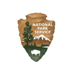 National Park logo, brown arrowhead with tree, mountain and buffalo