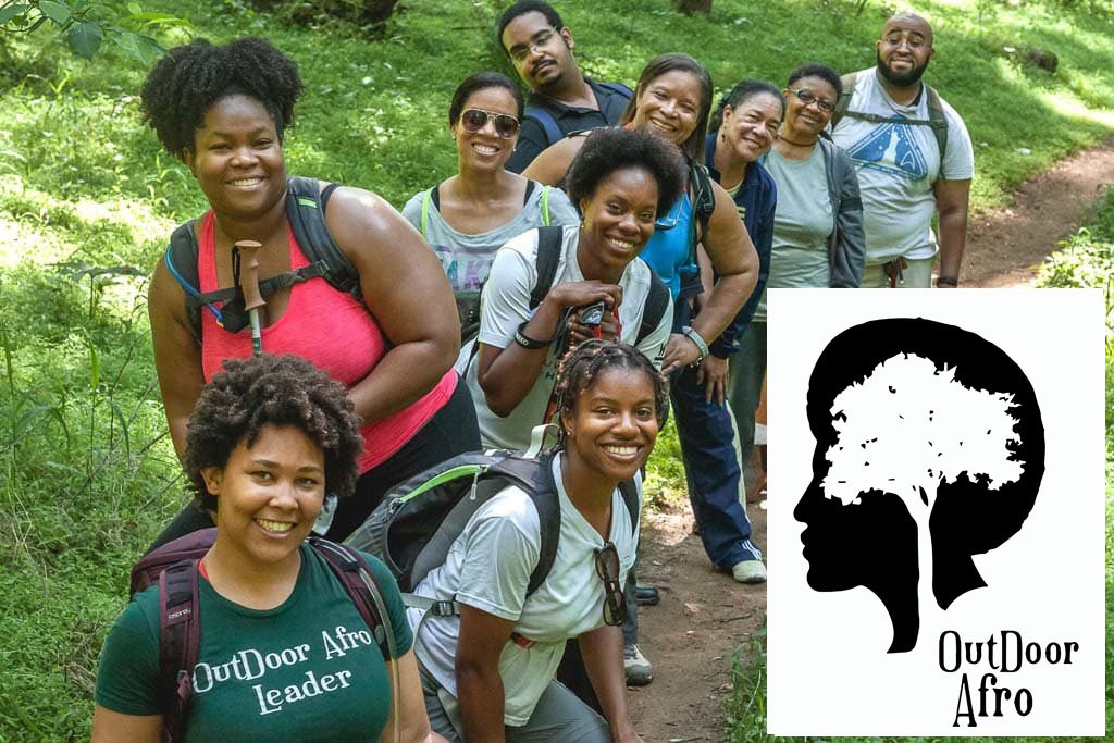 A group of young black adults are hiking a trail in the summer on a hill and the Outdoor Afro logo