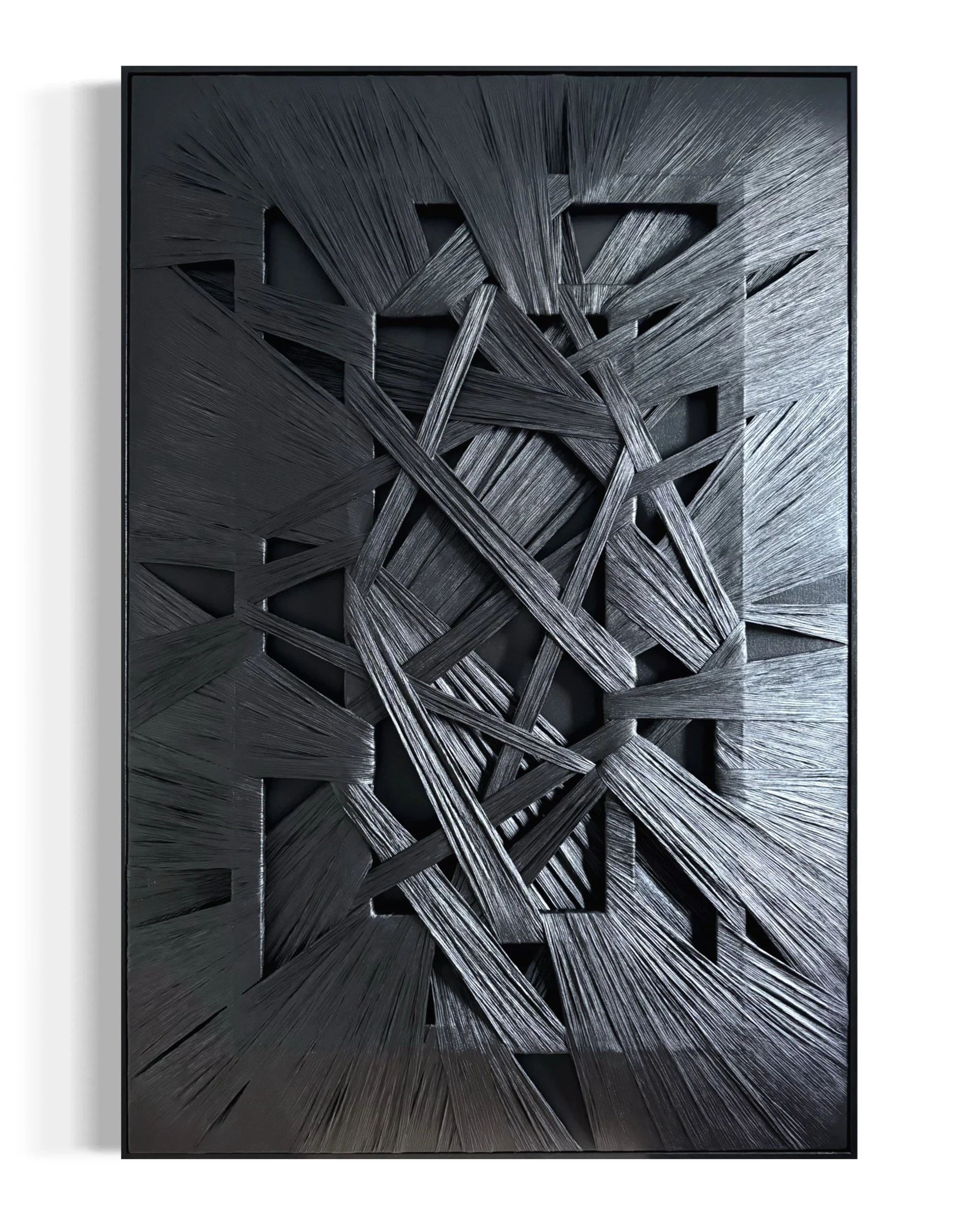 Black abstract art piece with textured, overlapping slats creating a geometric pattern.