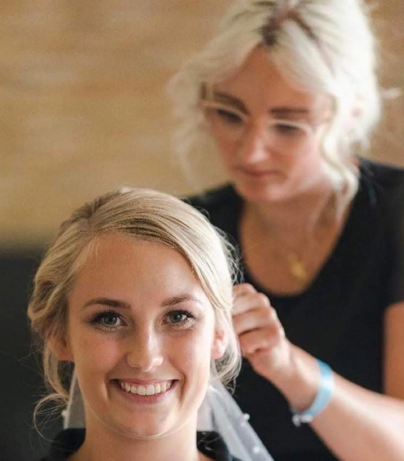 Brud med elegant opsat brudehår og naturlig makeup får sat slør af professionel stylist fra RiiStyle på bryllupsdagen