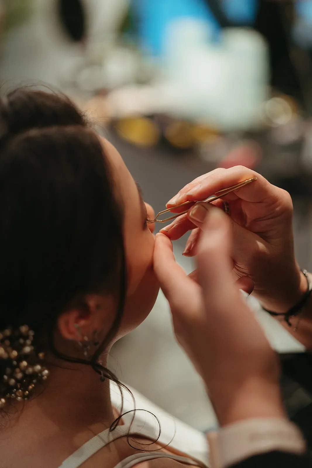 nærbillede af vipper der påsættes med pincet så brudemakeuppen fuldendes