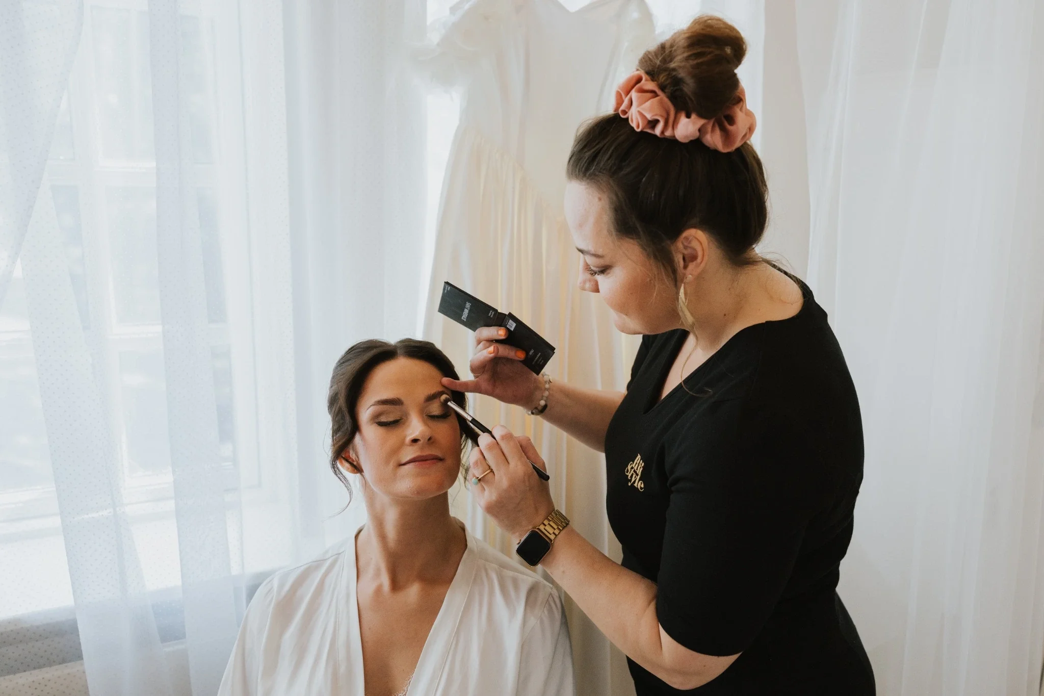 Brud får lagt makeup af professionel stylist fra RiiStyle på bryllupsdagen i bløde, lyse omgivelser