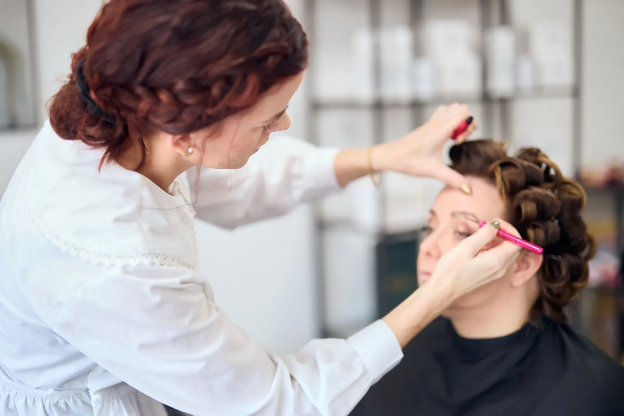 Makeup artist forbereder brudens look under prøvestyling hos RiiStyle