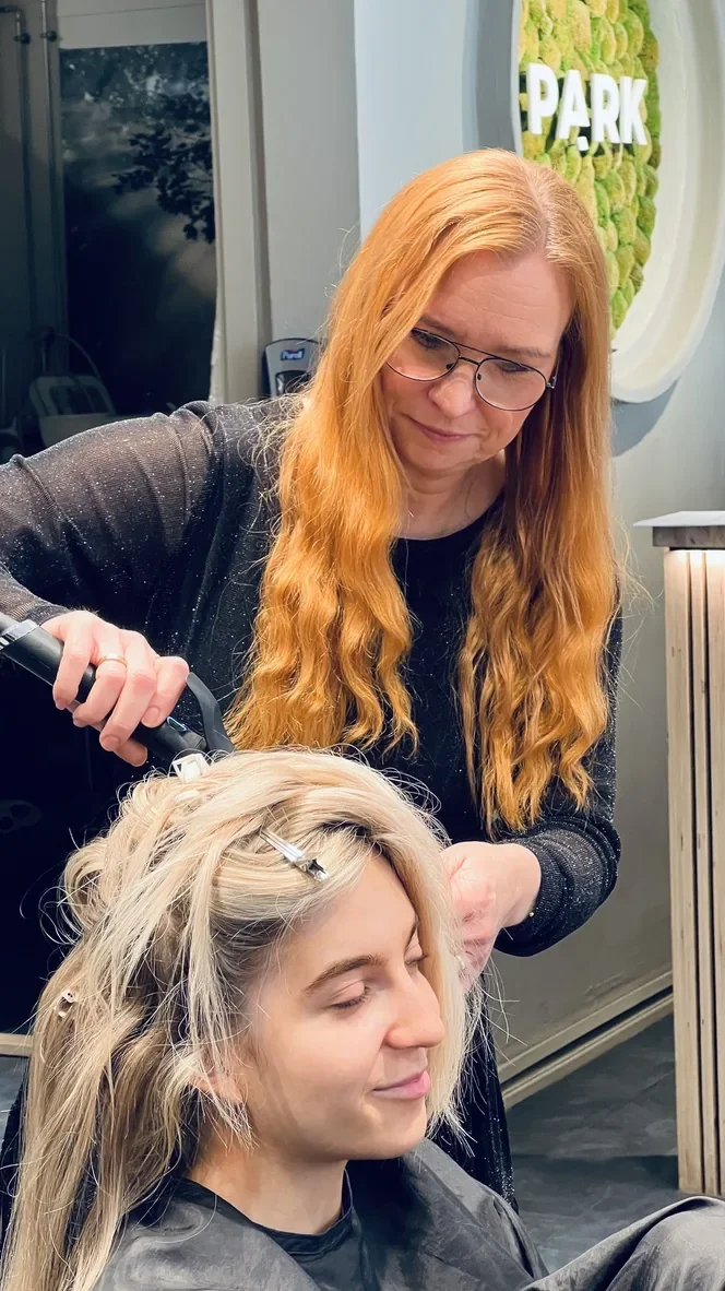Frisør Helle er igang med at forberede brundes hår inden håret skal sættes op