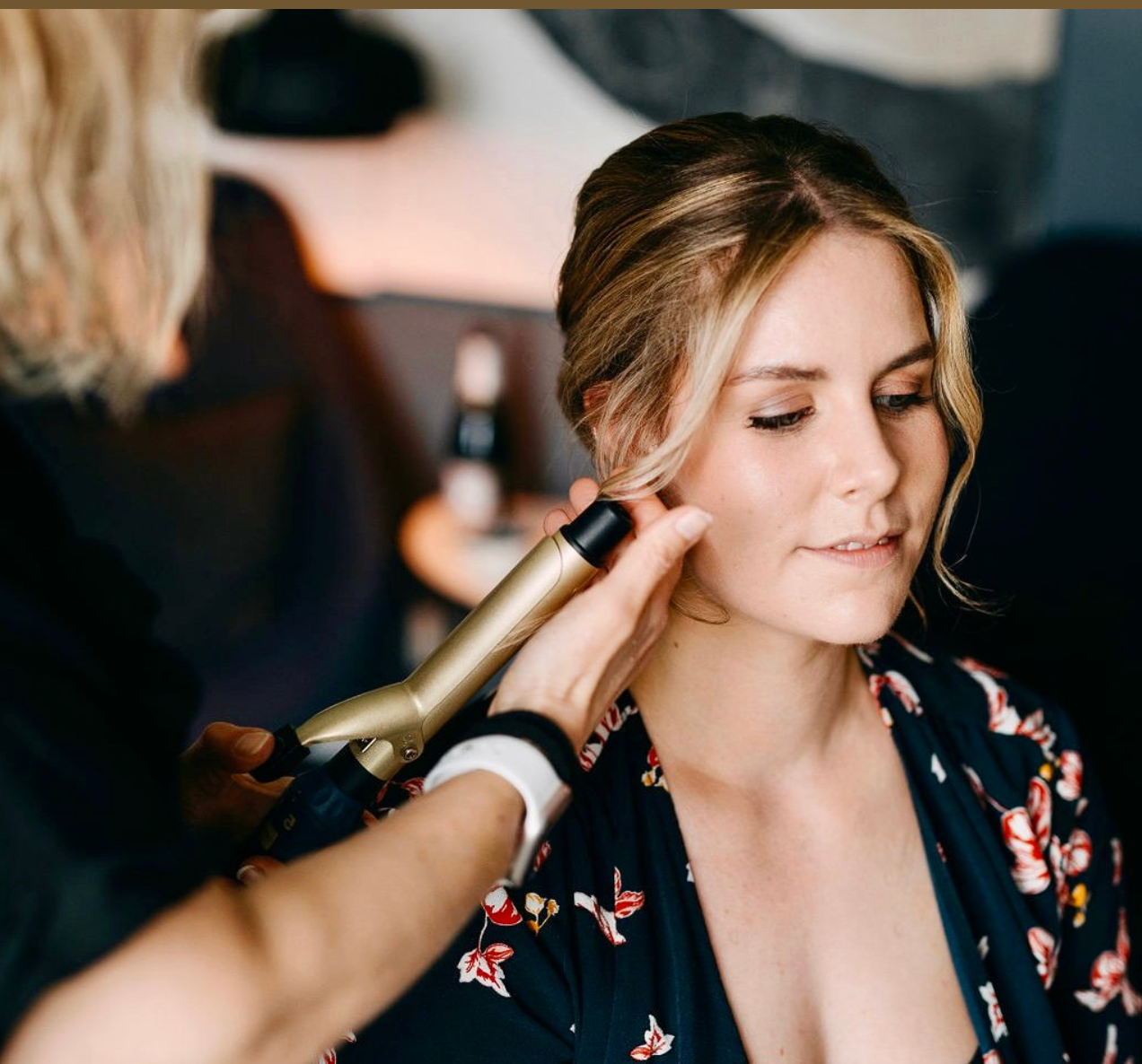 Kvinde bliver få klippet håret med en krøllejern på en frisørsalon.