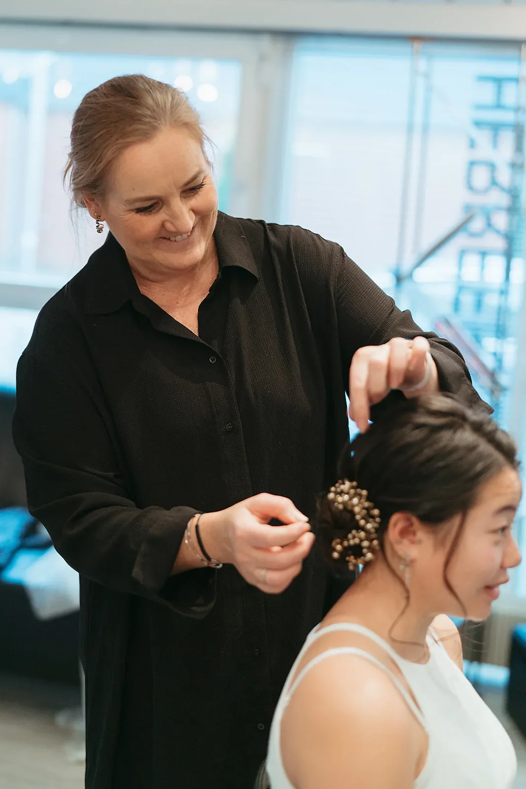 Frisøt og makeupartist Kristine laver de sidste detaljer med perlesmykke i brudehår