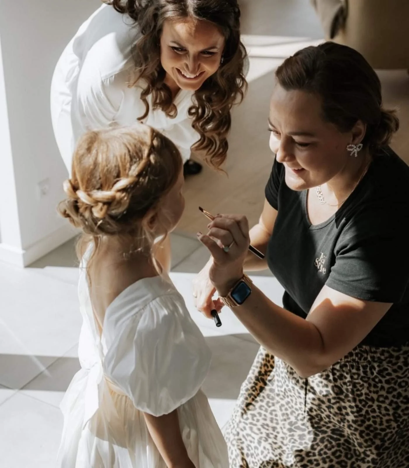 Stylist sætter slør på brud med elegant brudehårsopsætning – rolig og professionel bryllupsforberedelse hos RiiStyle.
