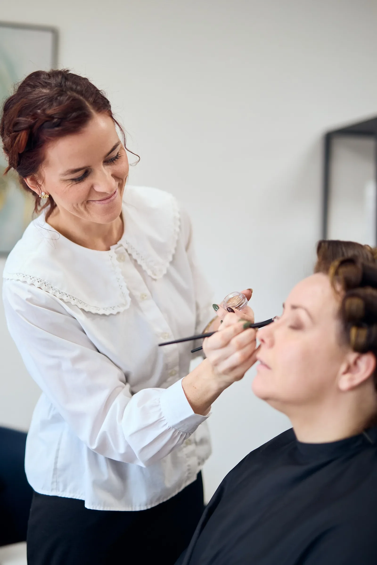 Pernille lægger sidste hånd på den smukke og naturlige brudemakeup og gylden øjenskygge