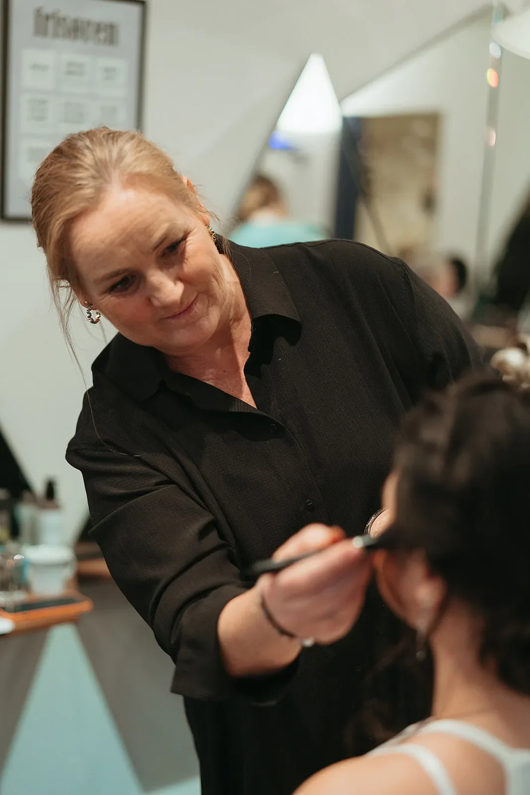 Brudestylist Kristine arbejder med de sidste detaljer på brudemakeuppen