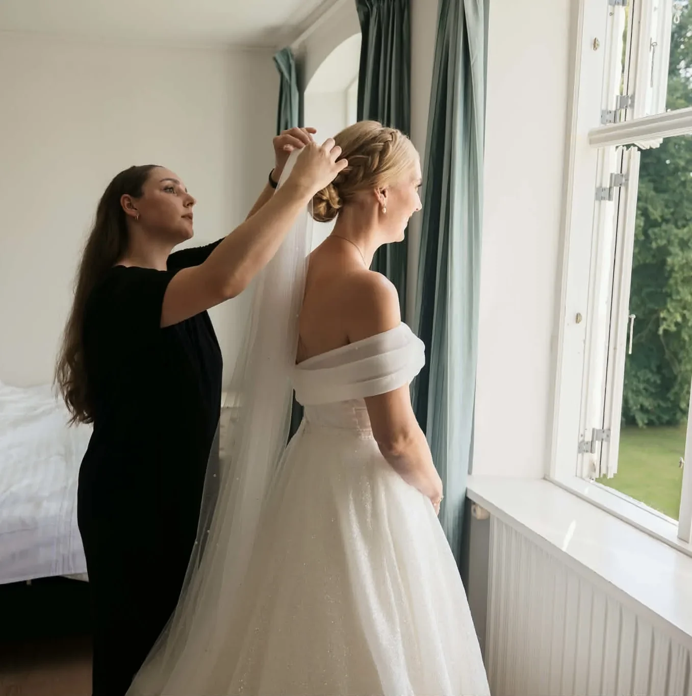 Frisør giver bruden slør på den smukke klassiske knold med fletning