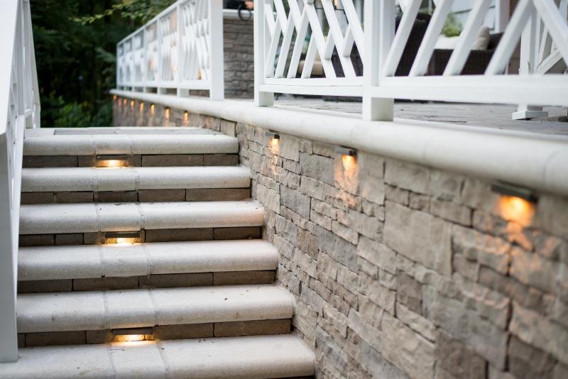  Image of a white and grey stone stairway ad retaining wall illuminated with ledge lights.  