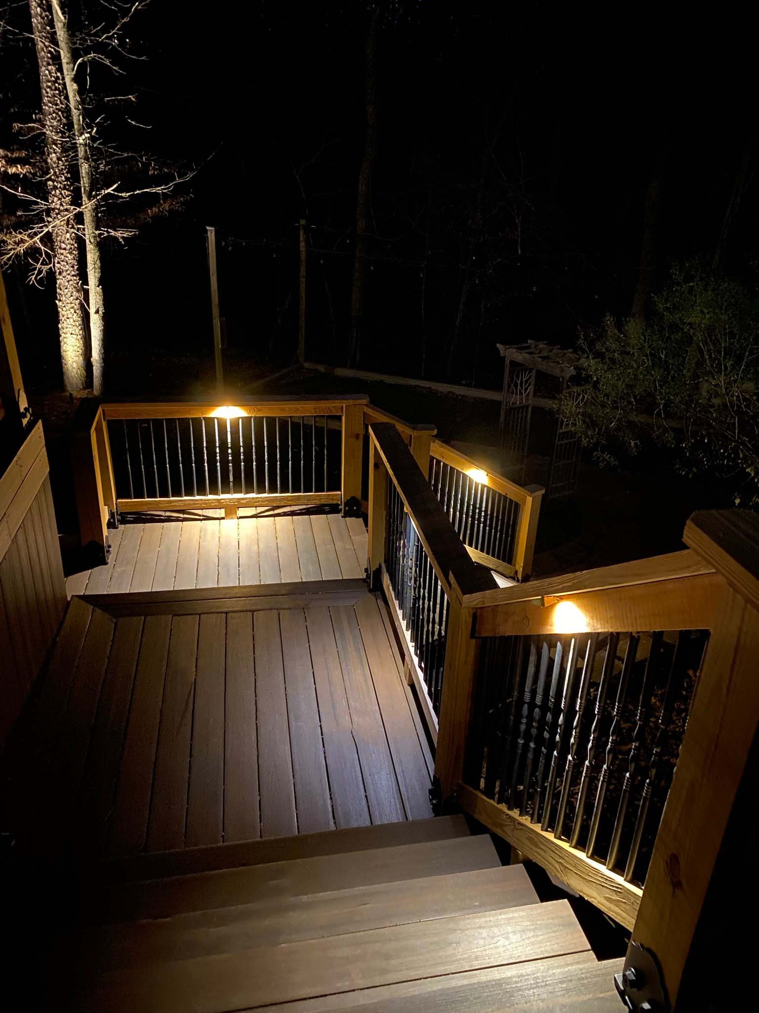  Deck and stairway illuminated with deck lighting mounted under the railings.  
