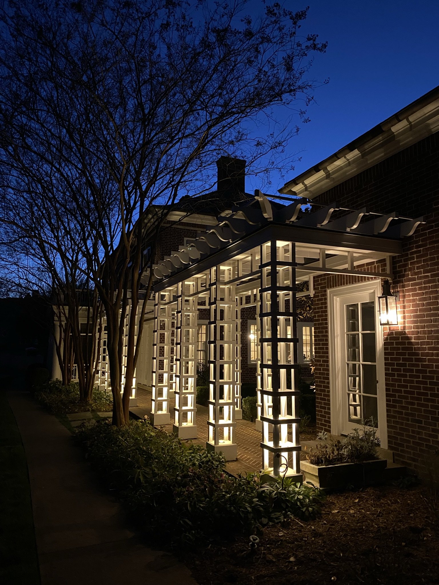  Pergola walkway illuminated with lights mounted inside the columns creating interesting patterns of shadow and light. 