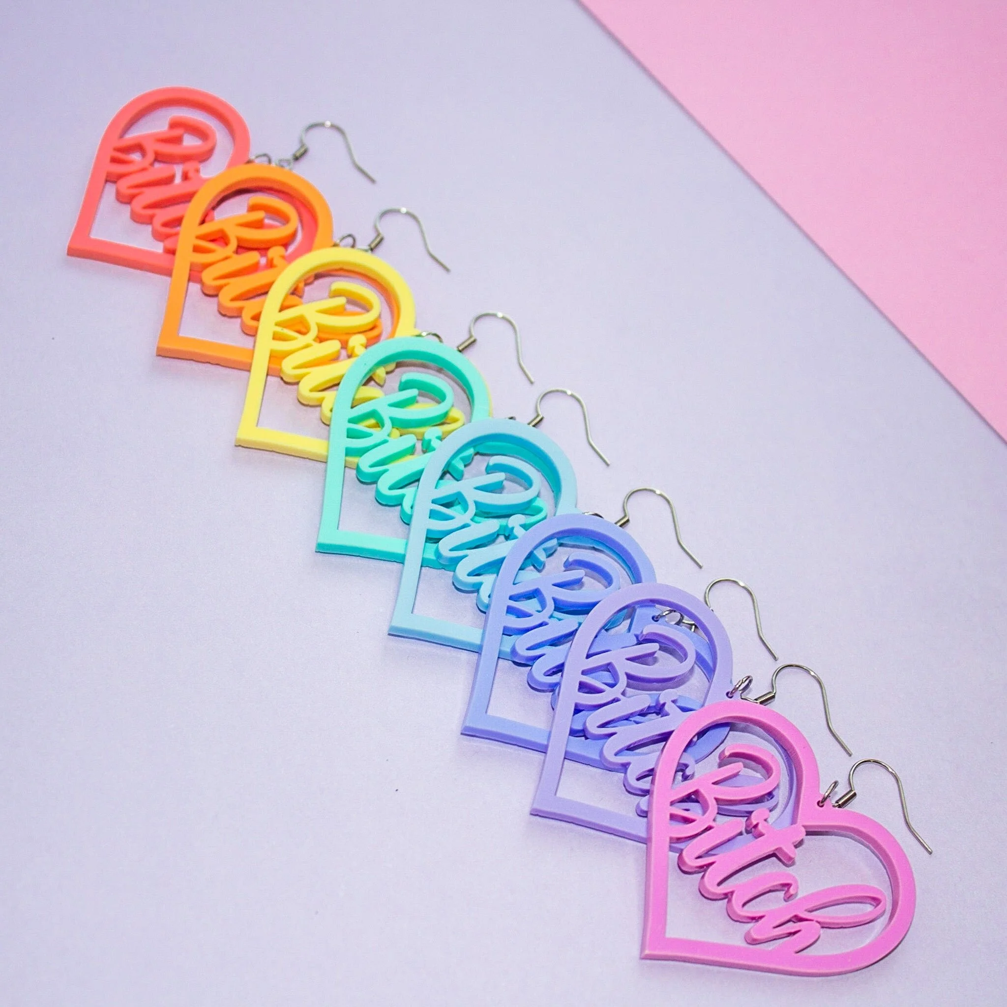 Colorful heart-shaped earrings with script text