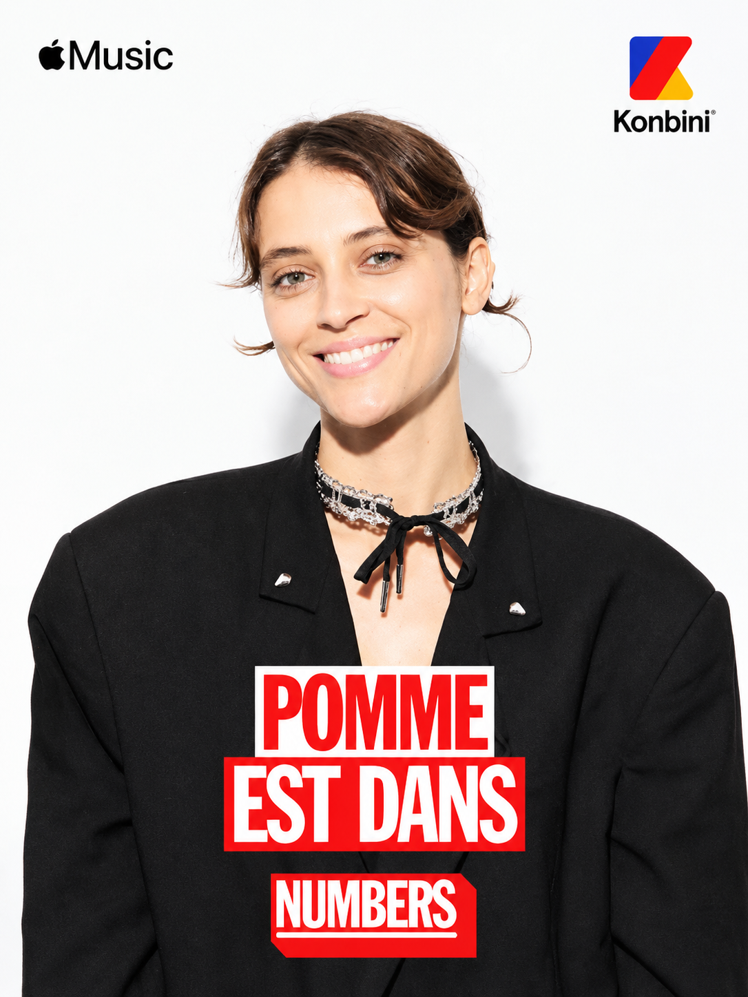 La chanteuse POMME souriante porte un blazer noir Guillaume Larquemain. Interview pour Apple Music et Konbini.