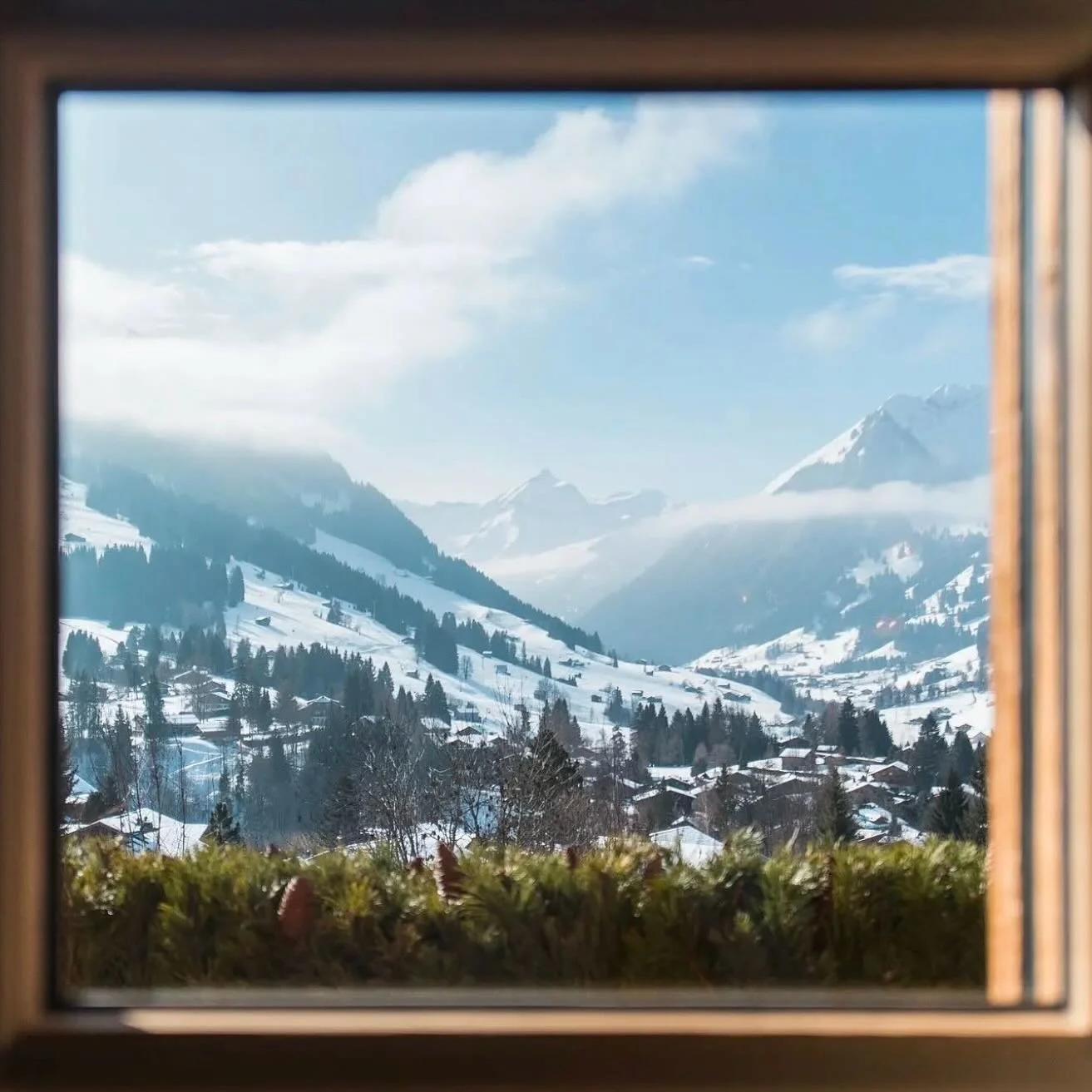 A Winter&rsquo;s Whisper

Through frosted glass, the mountains gleam,
A quiet world of snow and dream.
A deer steps softly, draped in white,
Graceful shadows blend with light.

Silver bows on candles glow,
Their flames a dance, serene and slow.
An el