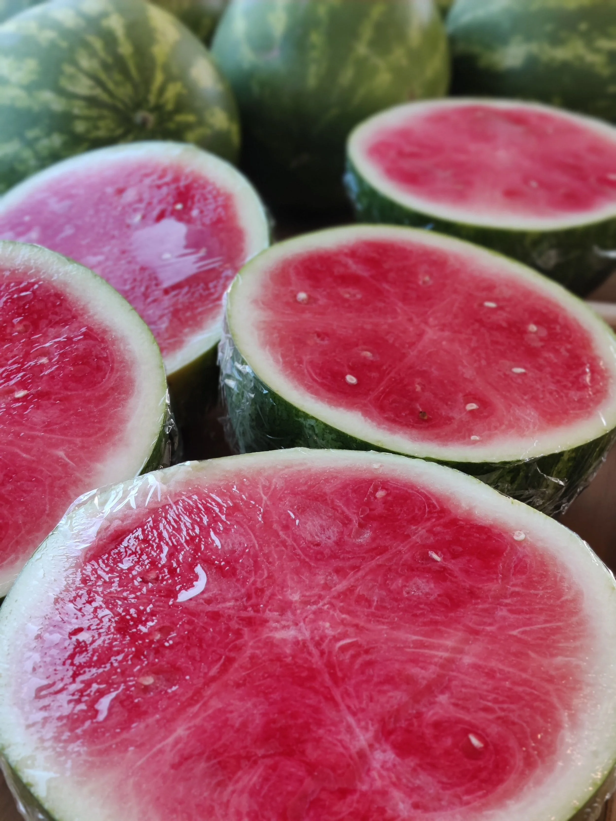 Juicy, sweet seedless red watermelon halves lined up halves