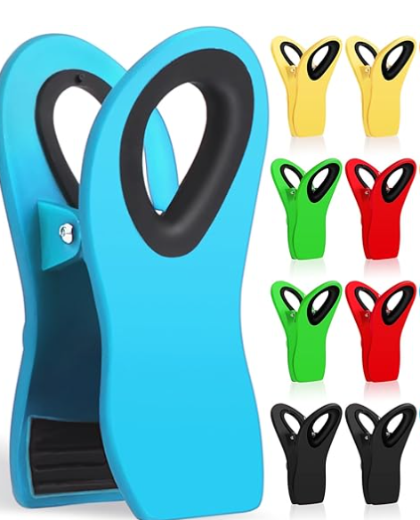 A set of colorful swim fins in yellow, green, red, and black with black foot openings, displayed in front of a larger blue pair of fins with a black foot opening, all arranged vertically.