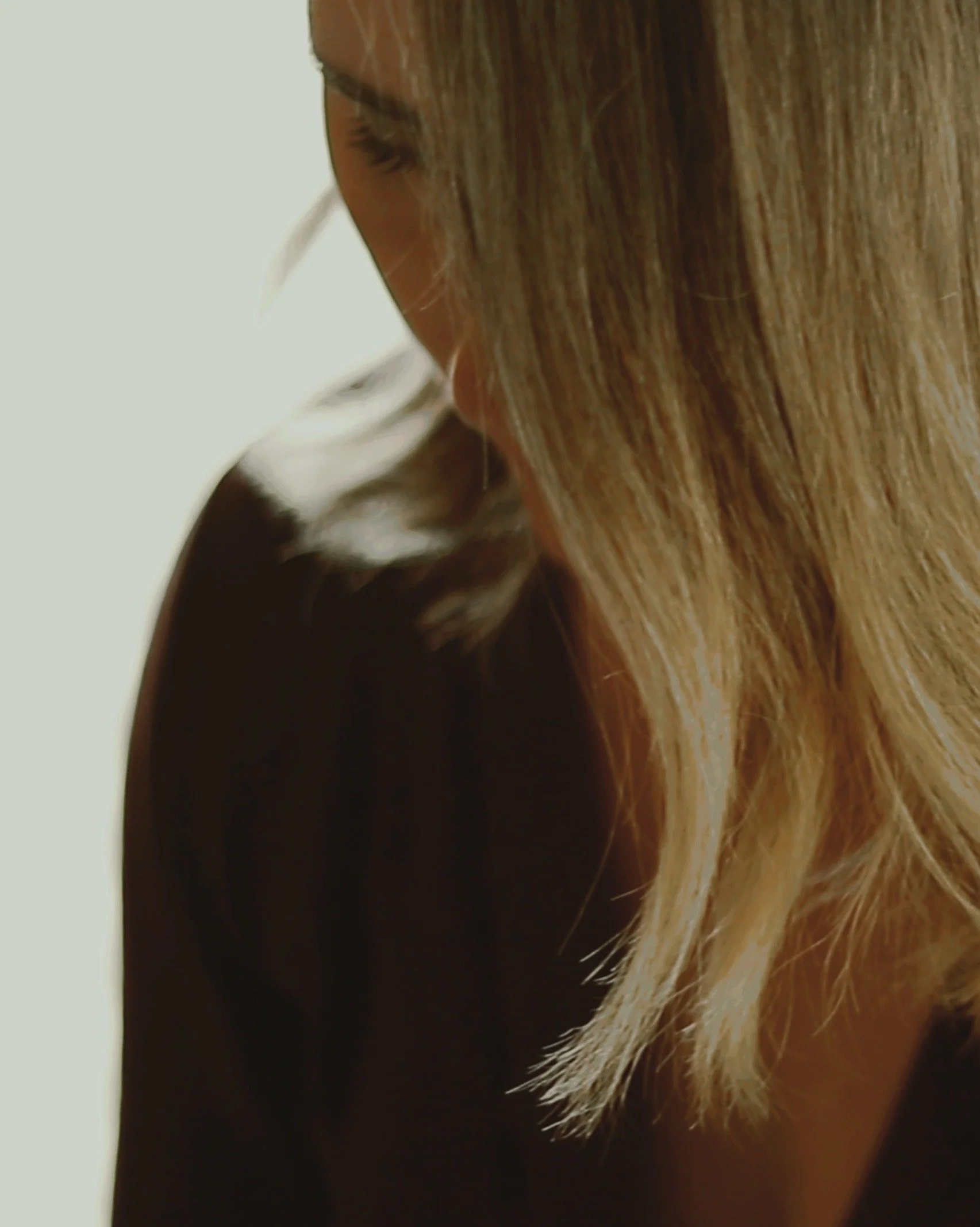 Close-up of a woman with light brown hair, focusing on its face and nose.