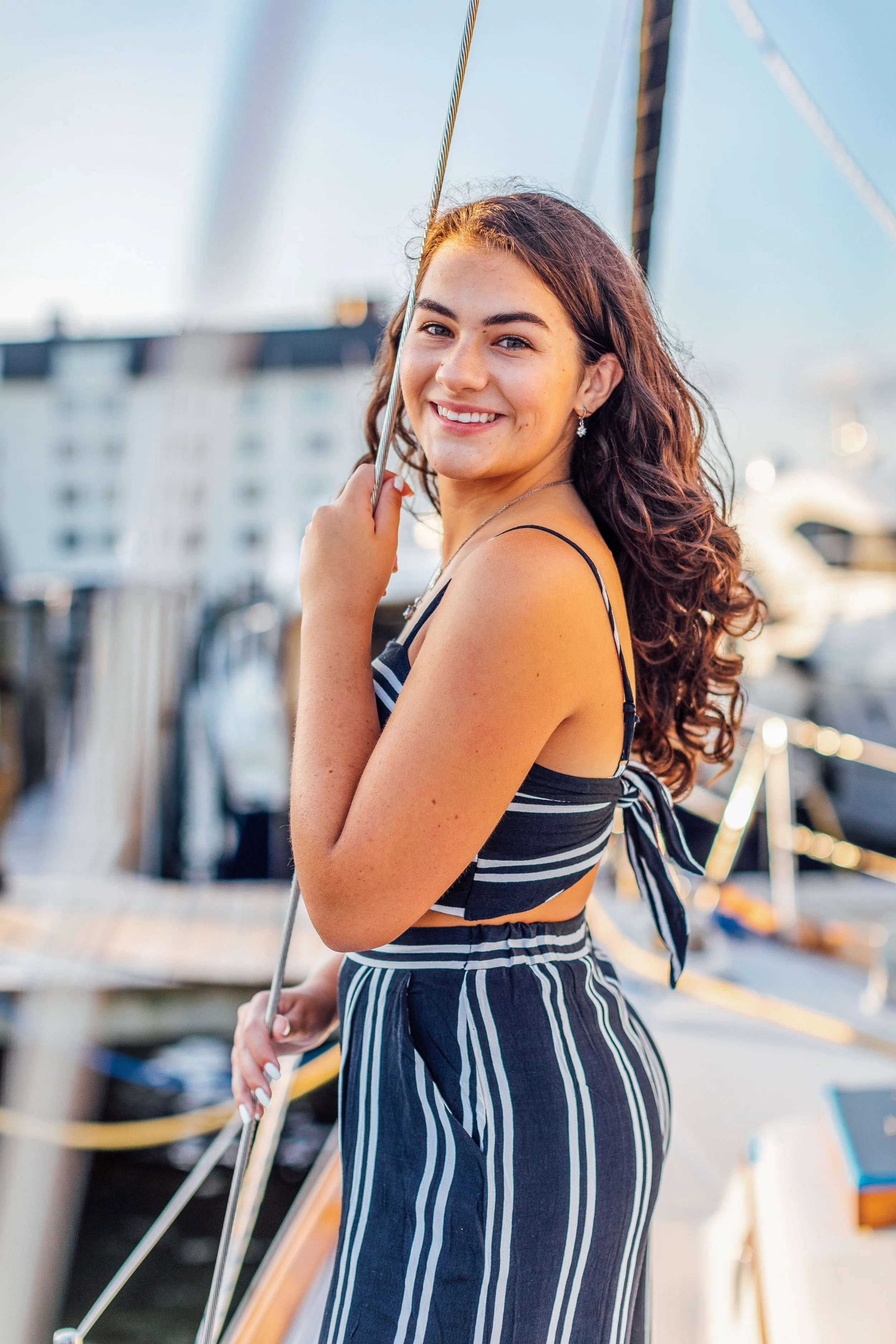 Leaning against the ropes on a boat for her senior portraits in Annapolis Maryland.