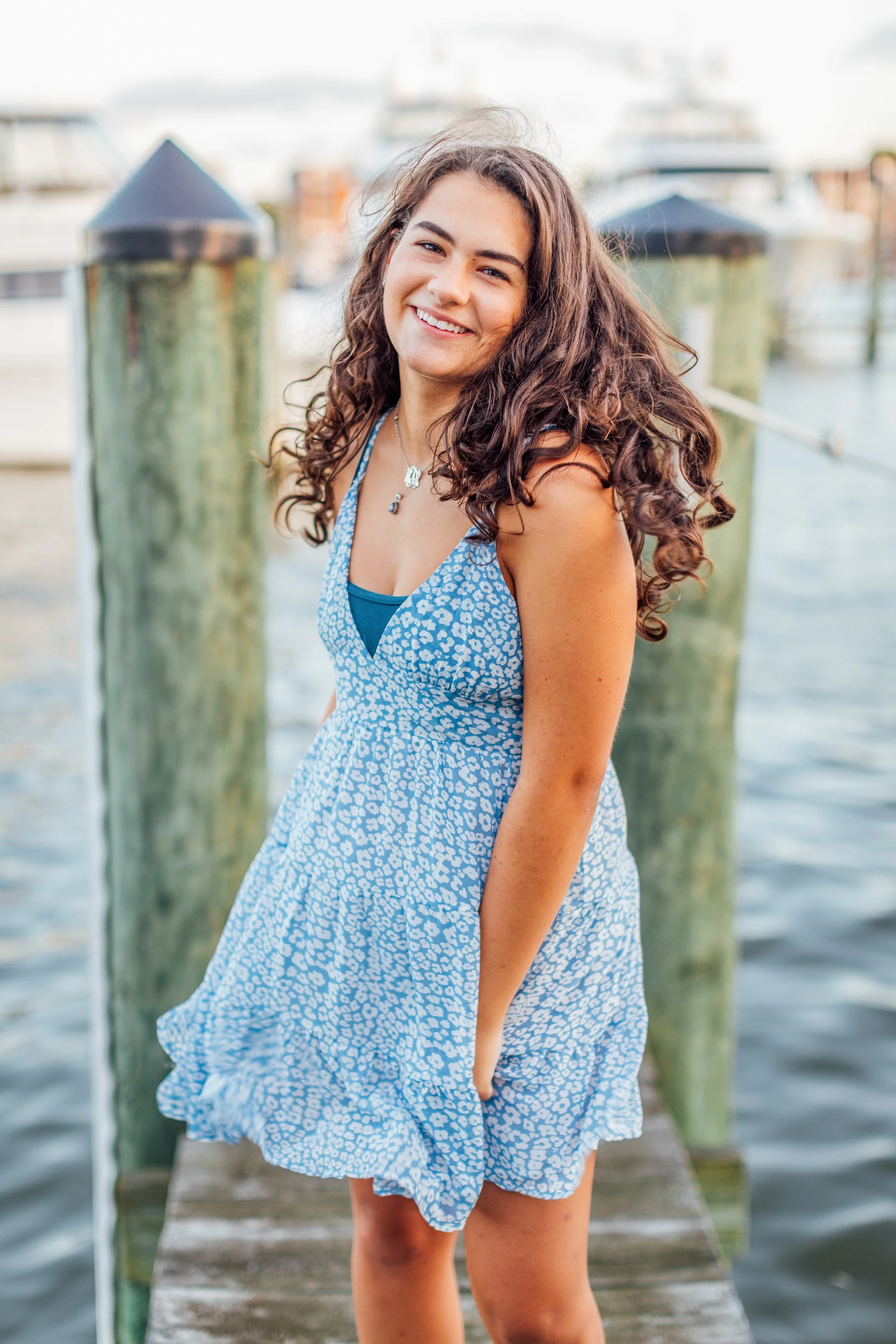 Heidi laughing and smiling on the dock in Downtown Annapolis near the Annapolis Yacht Club for her senior photos.