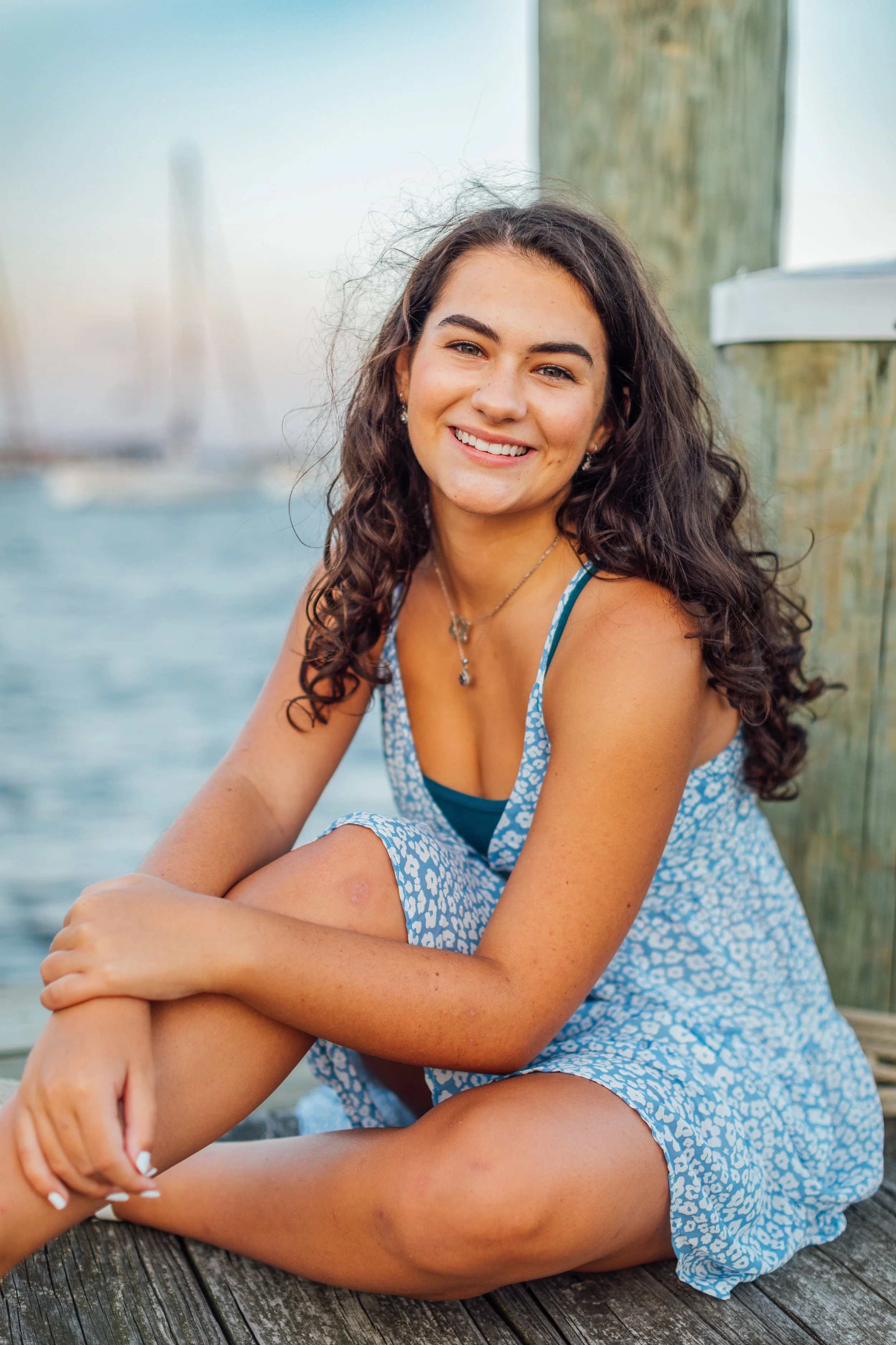 Heidi sitting on the dock in Downtown Annapolis during her senior portrait photo session.