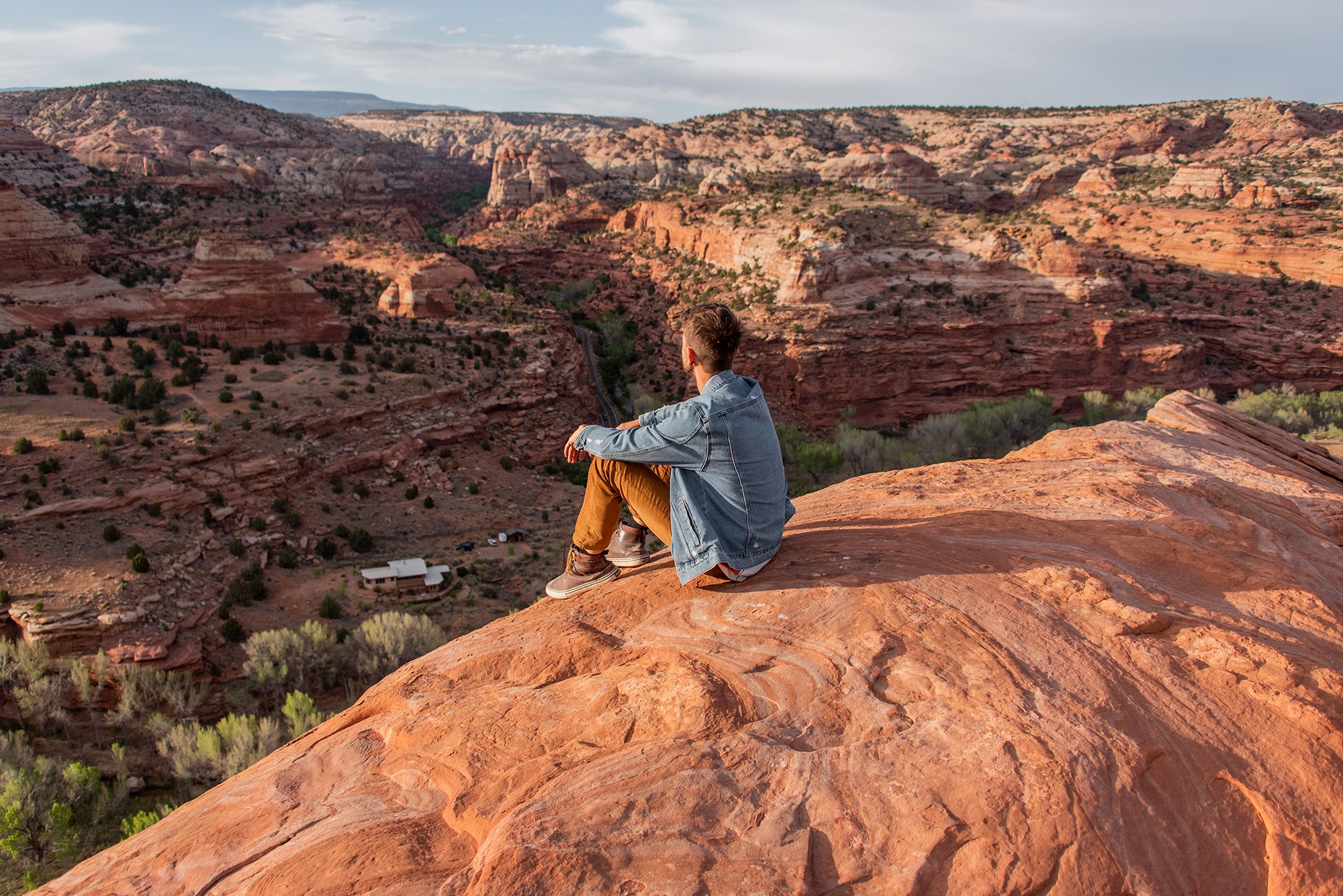 man sitting atop cliff in Grand Staircase National Monument