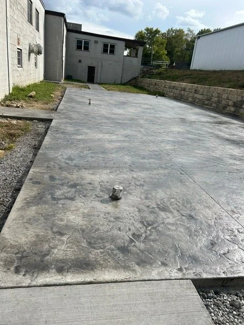 Concrete driveway stretching from the foreground towards a building in the background