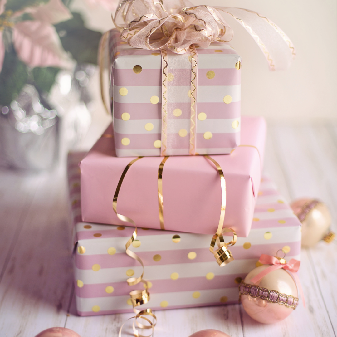 Pink gifts under a christmas tree .png