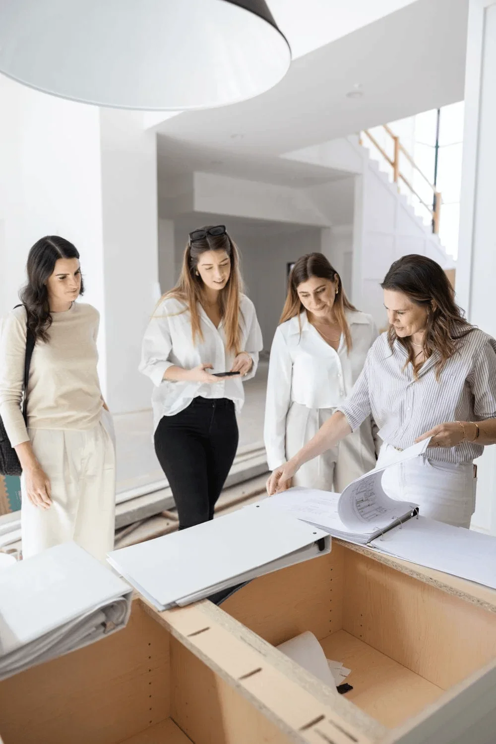 Interior design consultation and site walkthrough with clients reviewing architectural drawings and plans during home renovation project by The Whistling Well New York.webp