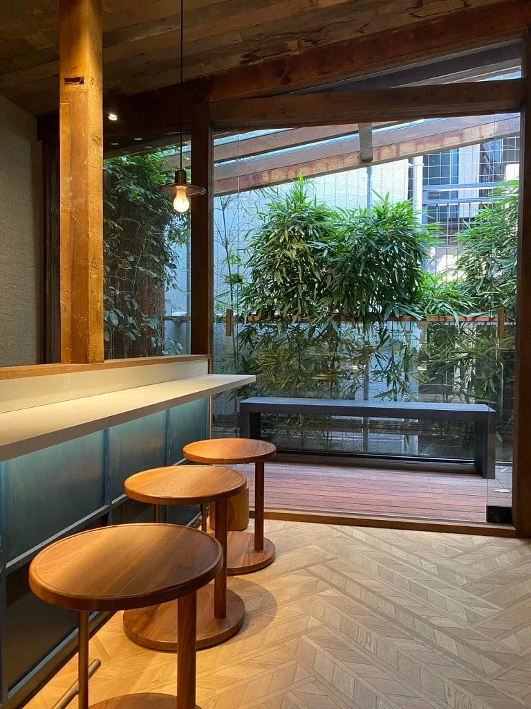 Biophilic cafe interior bamboo garden wood stools.webp