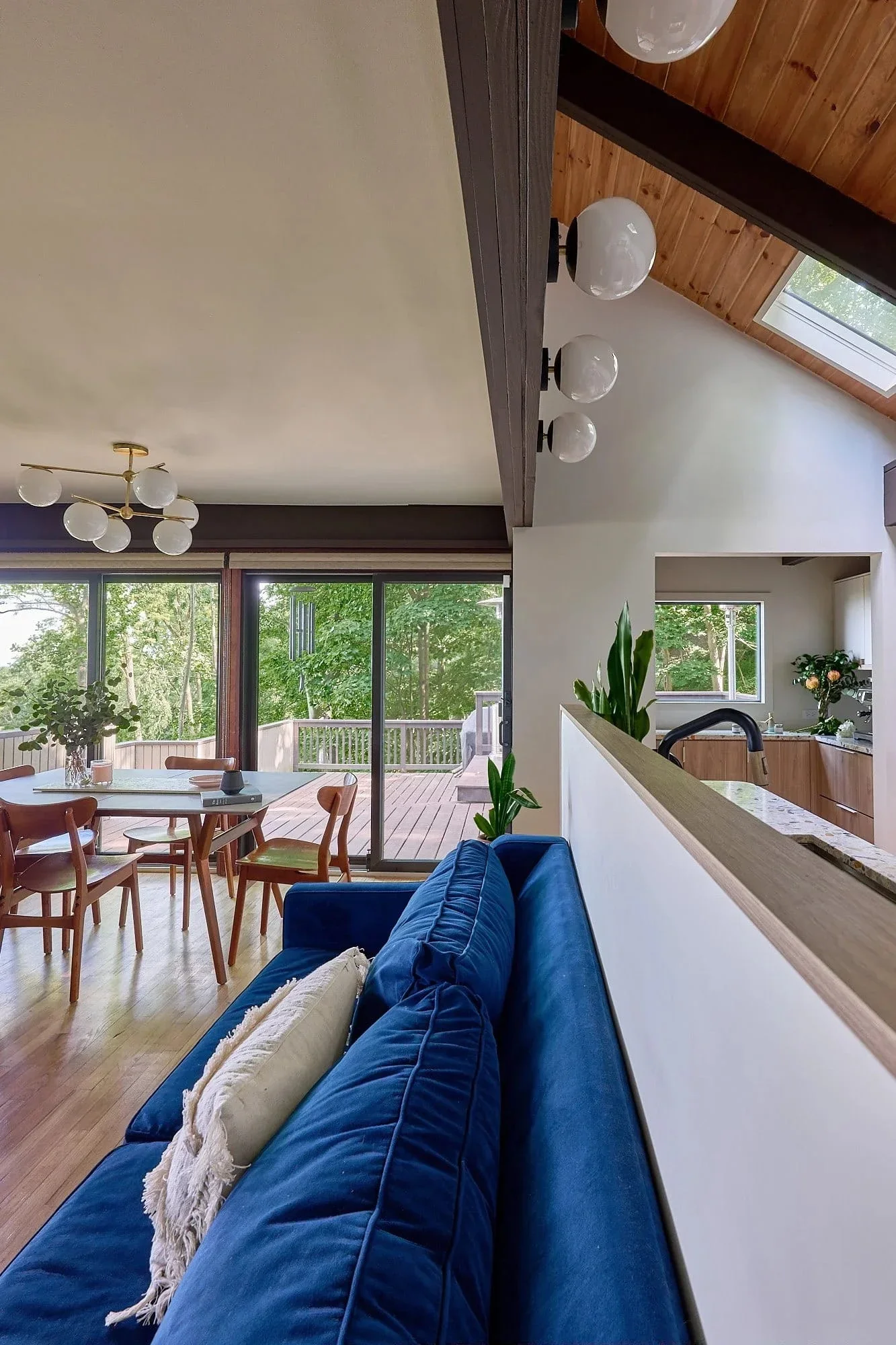 Mid century open plan blue sofa forest views.webp
