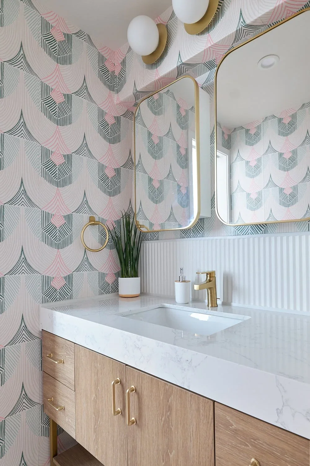 Playful bathroom design art deco wallpaper brass fixtures.webp