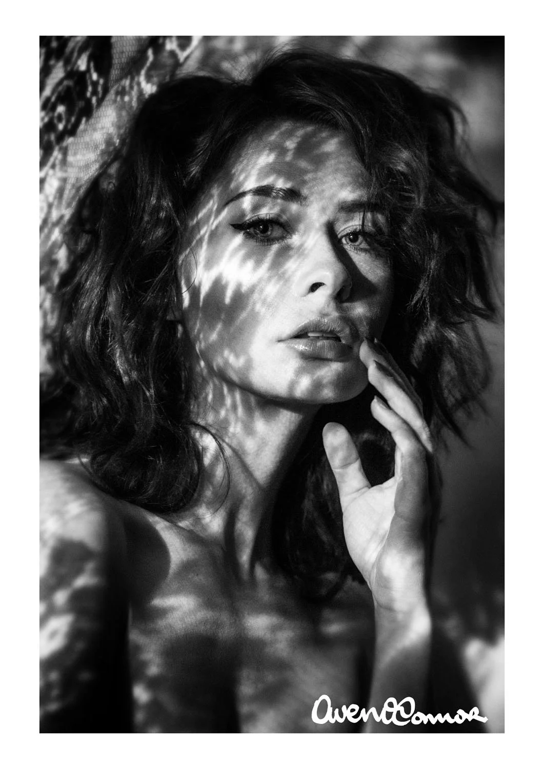Black and white portrait of a woman with wavy hair, shadows on her face, and the signature 'Owen Cannon' at the bottom right.