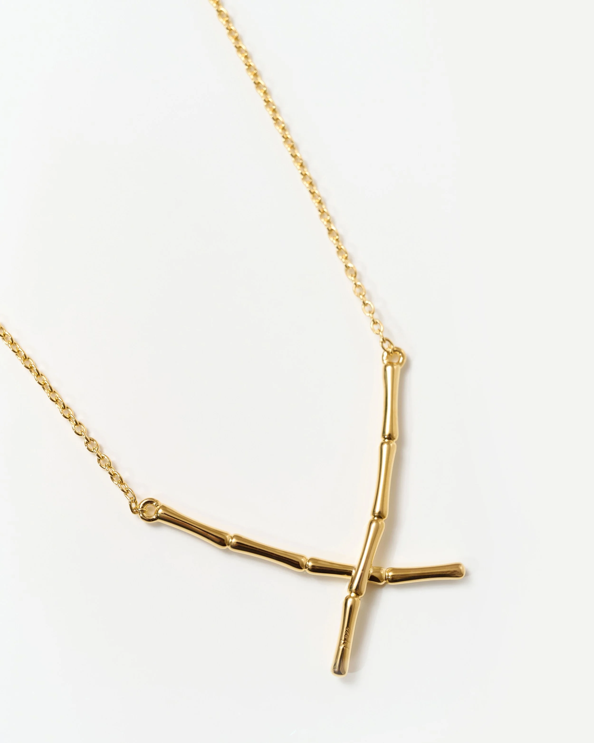 Gold necklace with elongated bar links on a white background.  Jewellery packshot photography
