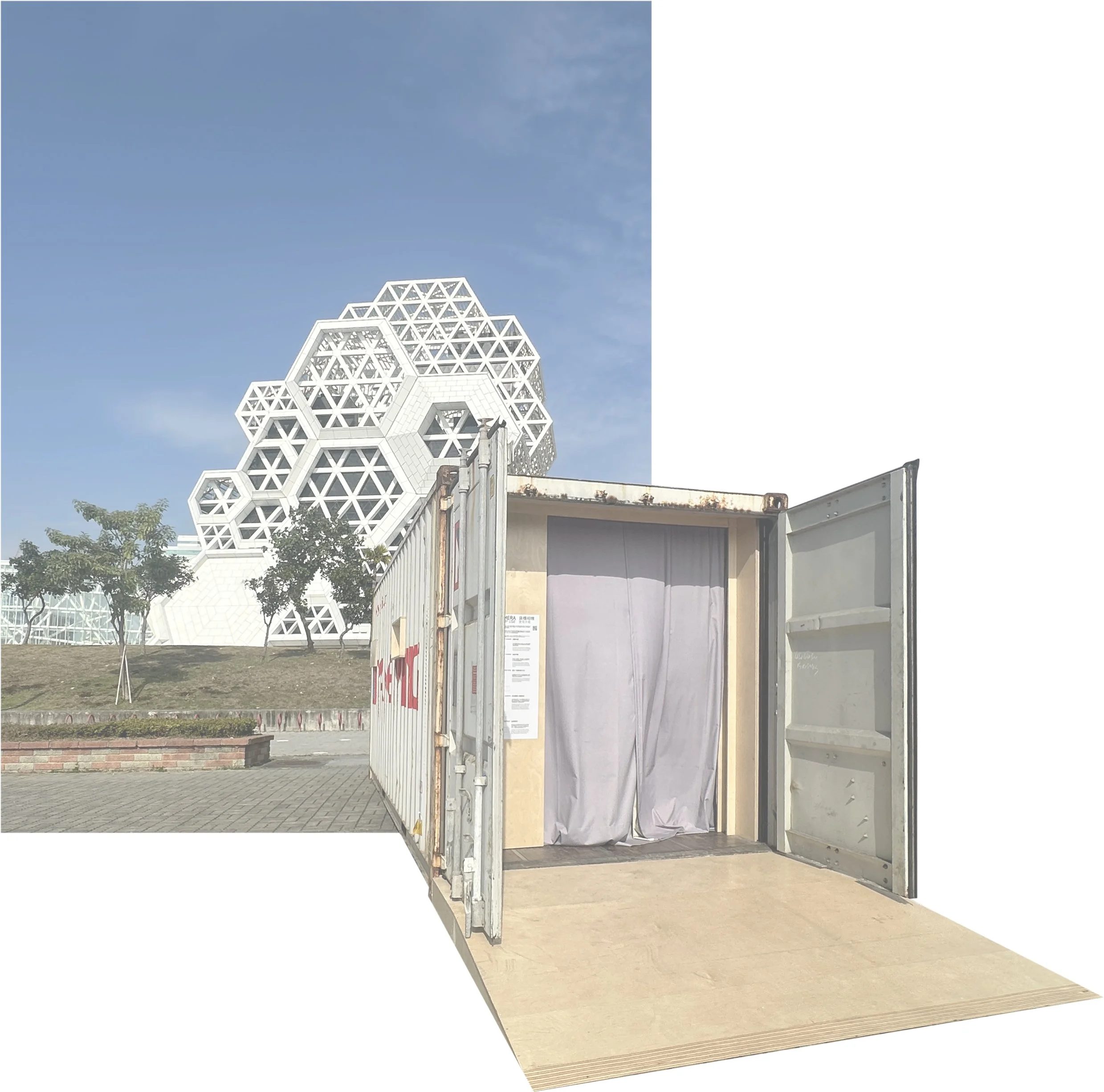 A shipping container with open doors, a curtain entrance just inside, and a wooden ramp at the front. It's placed outdoors, with a modern geometric building in the background under a blue sky.