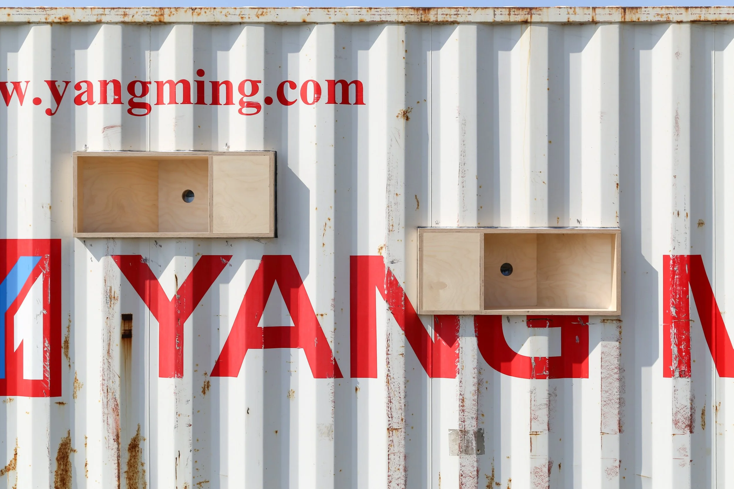 Exterior photo of the container, showing two of the unique plywood boxes, holding the lenses. By Autistic architect and artist, Troels Steenholdt Heiredal