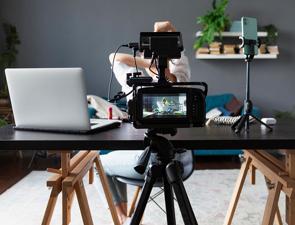 Small business owner creating social media content at home with camera setup for marketing and visibility