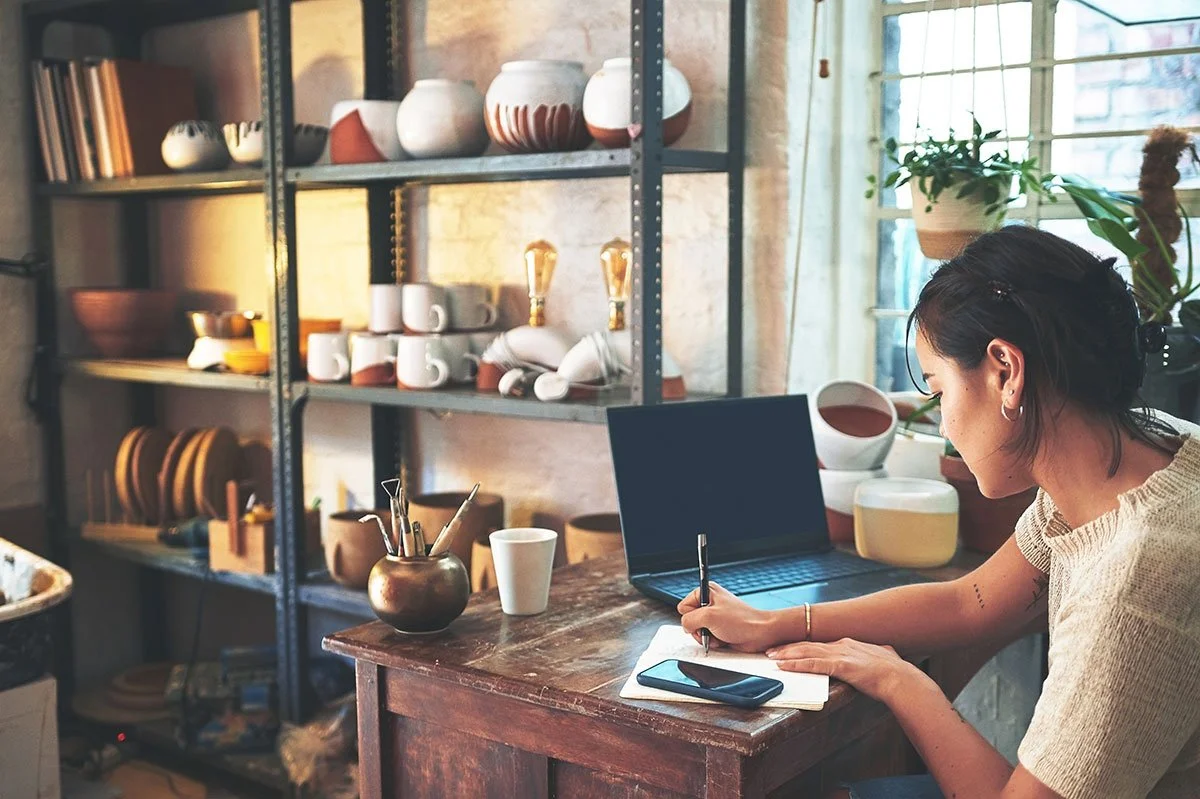 Service-area business owner working from a home workspace, planning tasks and managing online visibility for a small business.