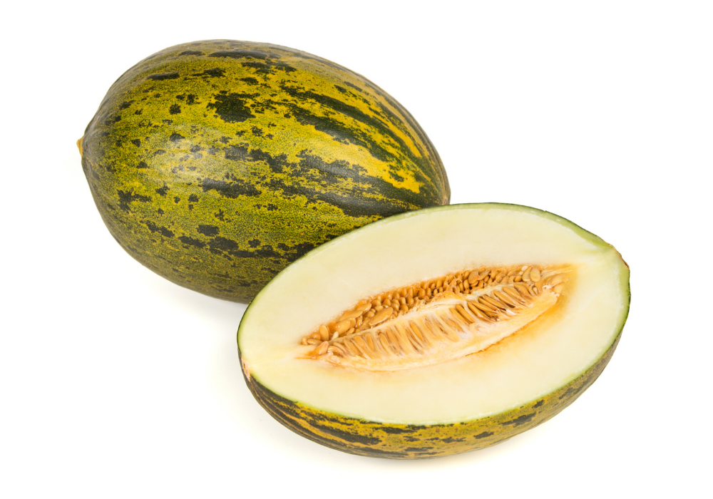 A whole cantaloupe melon with green and brown striped skin and a halved cantaloupe showing pale green flesh and orange seeds inside.