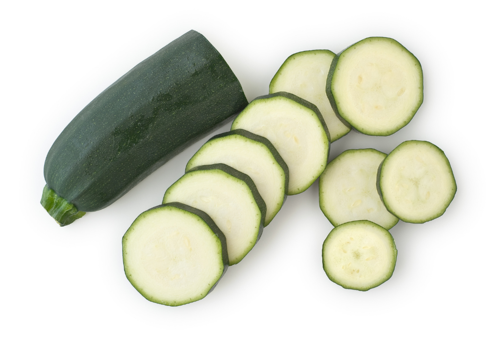 Whole zucchini with several slices cut and arranged on a white background.