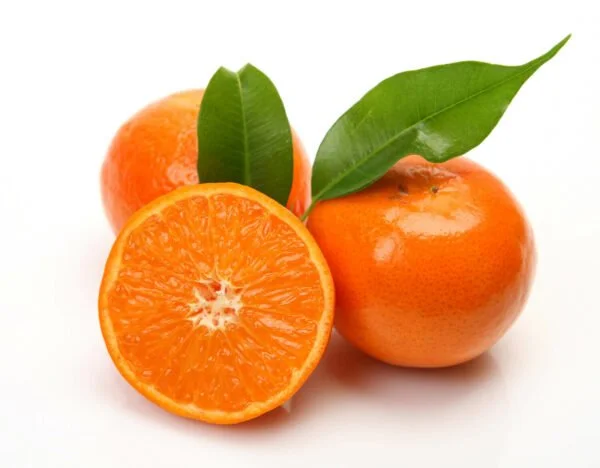 Three tangerines, one halved revealing orange flesh and two with green leaves attached, on a white background.