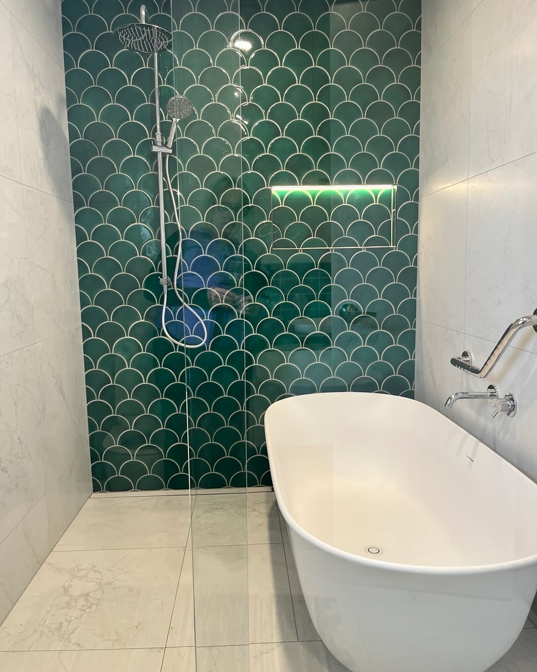 The longest bathroom renovation ever after a devastating fire but the result well worth it for this Breaker Bay home. A lovely pop of colour with some fish-scale tiles from Middle Earth with shower and bath now all behind a glass sliding screen. Grea